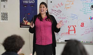 Shelley Terry teaches her class with congratulatory messages on the white board behind her.